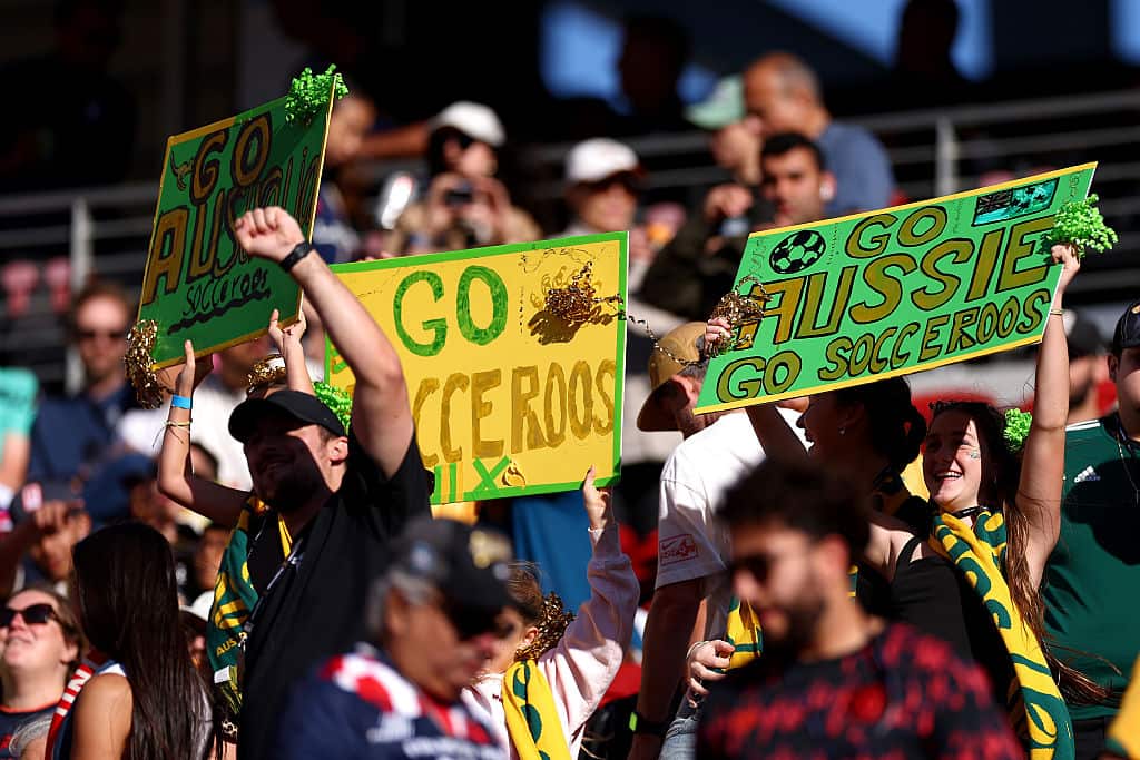 Fans holding up signs that read Go Socceroos