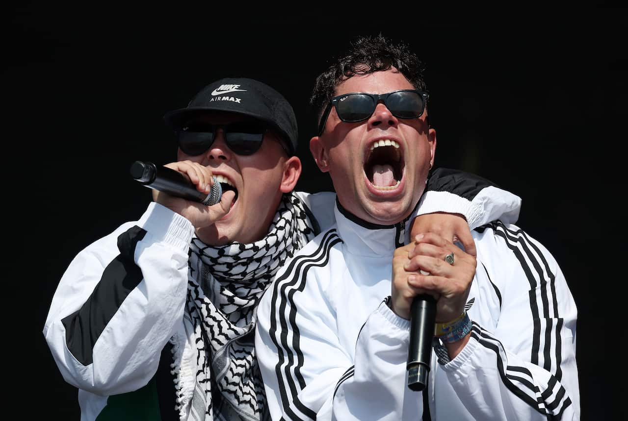 Two musicians with microphones, performing.