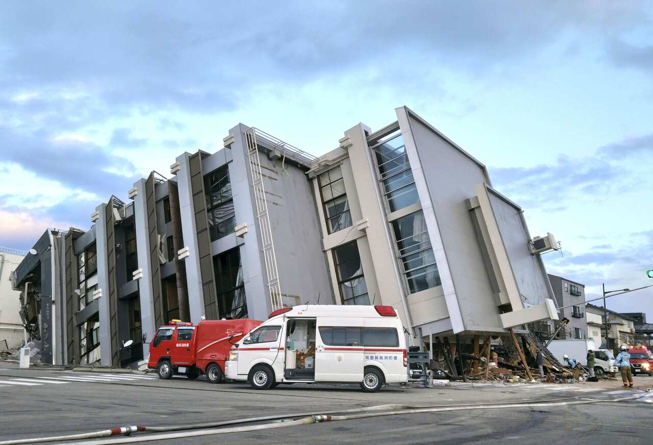 A building falls on the ground following an earthquake.