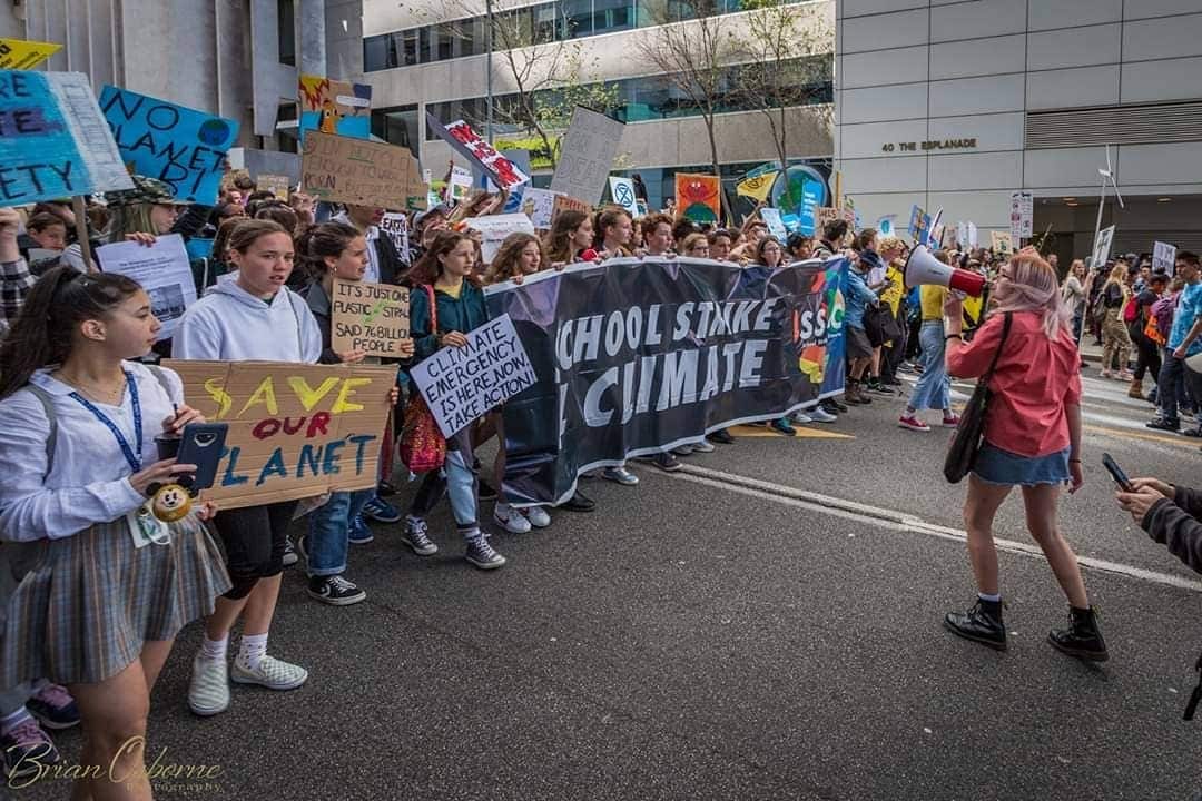 A young woman speaks in front of a group of protesters. 