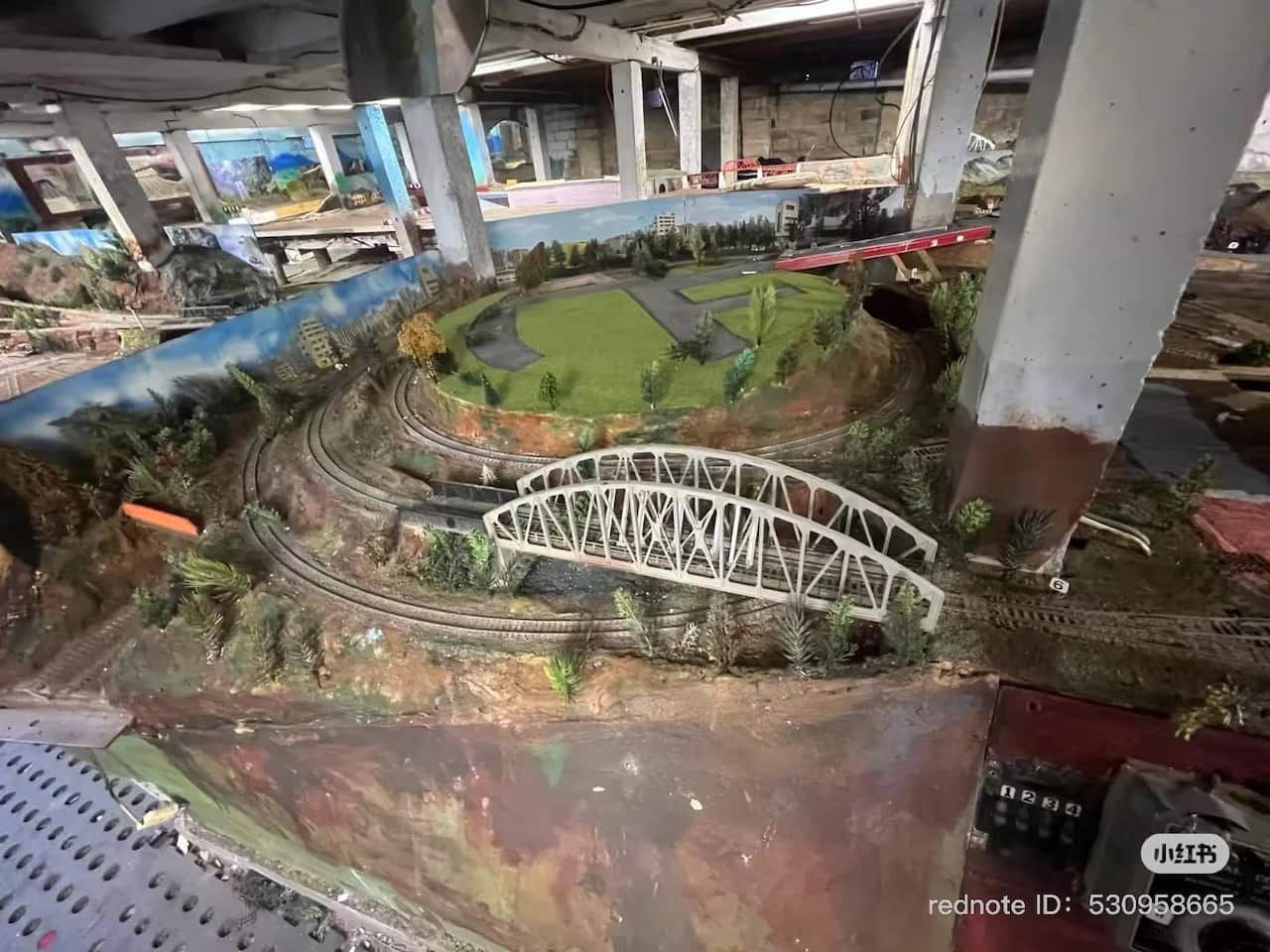 An extensive model train set in an enclosed area beneth a house.