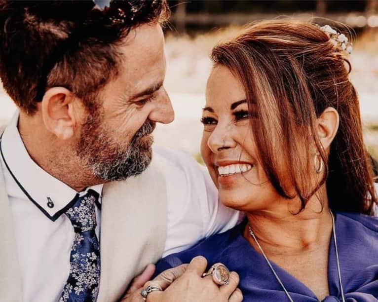 Darren and Jo Gittos embracing and smiling together outside.