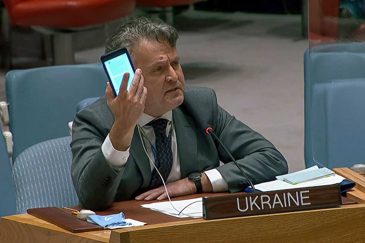 Ukraine's Ambassador to the United Nations Sergiy Kyslytsya, holds up a phone as he speaks at an emergency meeting of the UN Security Council Wednesday, 23 February, 2022, at UN headquarters. 