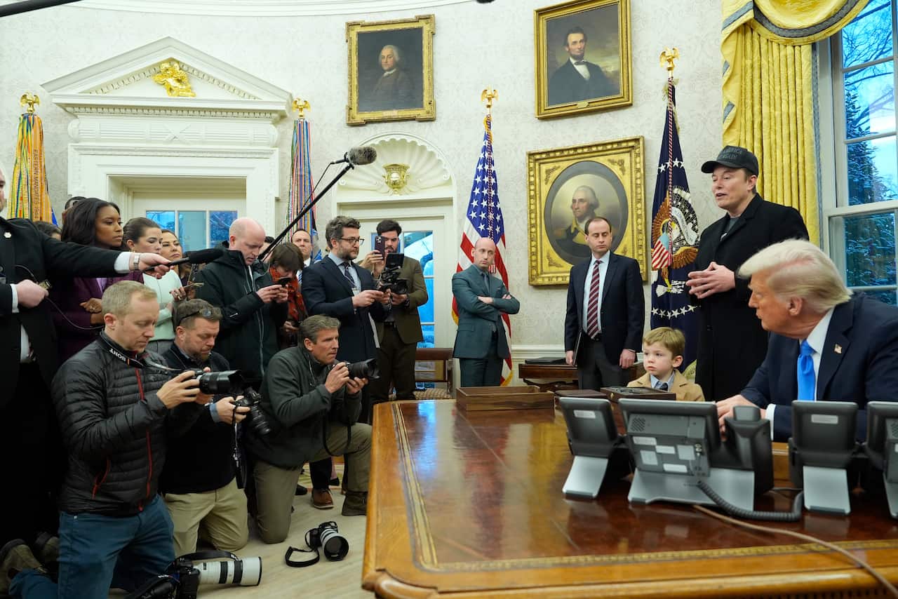 Donald Trump, Elon Musk and his son, 'Lil X" face a crowd of reporters in the Oval Office at the White House.