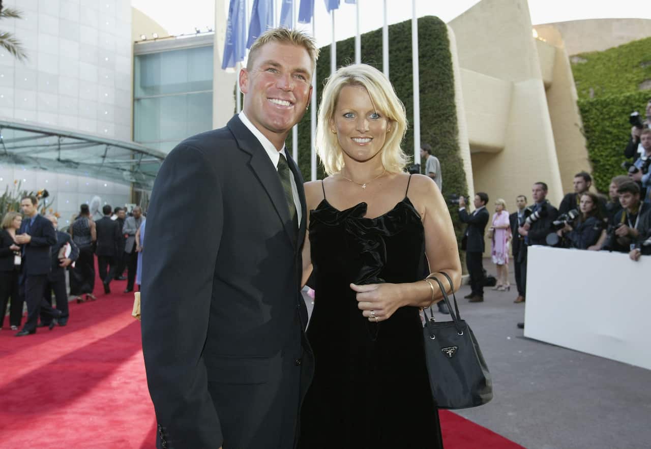 Shane Warne and his ex wife Simone smile as they pose for a photo.