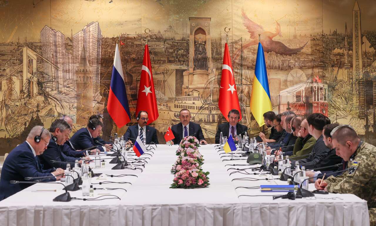 Men from Russian and Ukrainian delegations are seated around a table in a Turkish palace