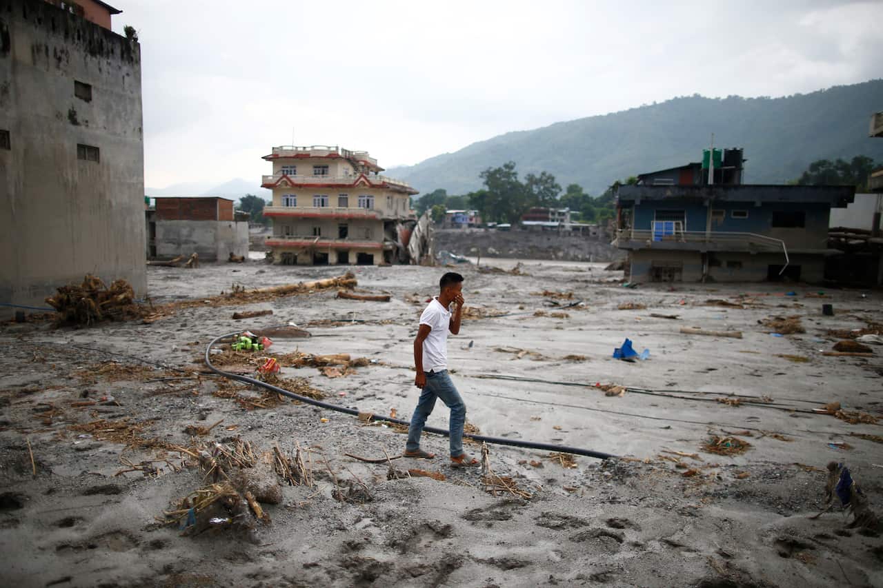 A man walks past a flood-affected area as rescue and relief