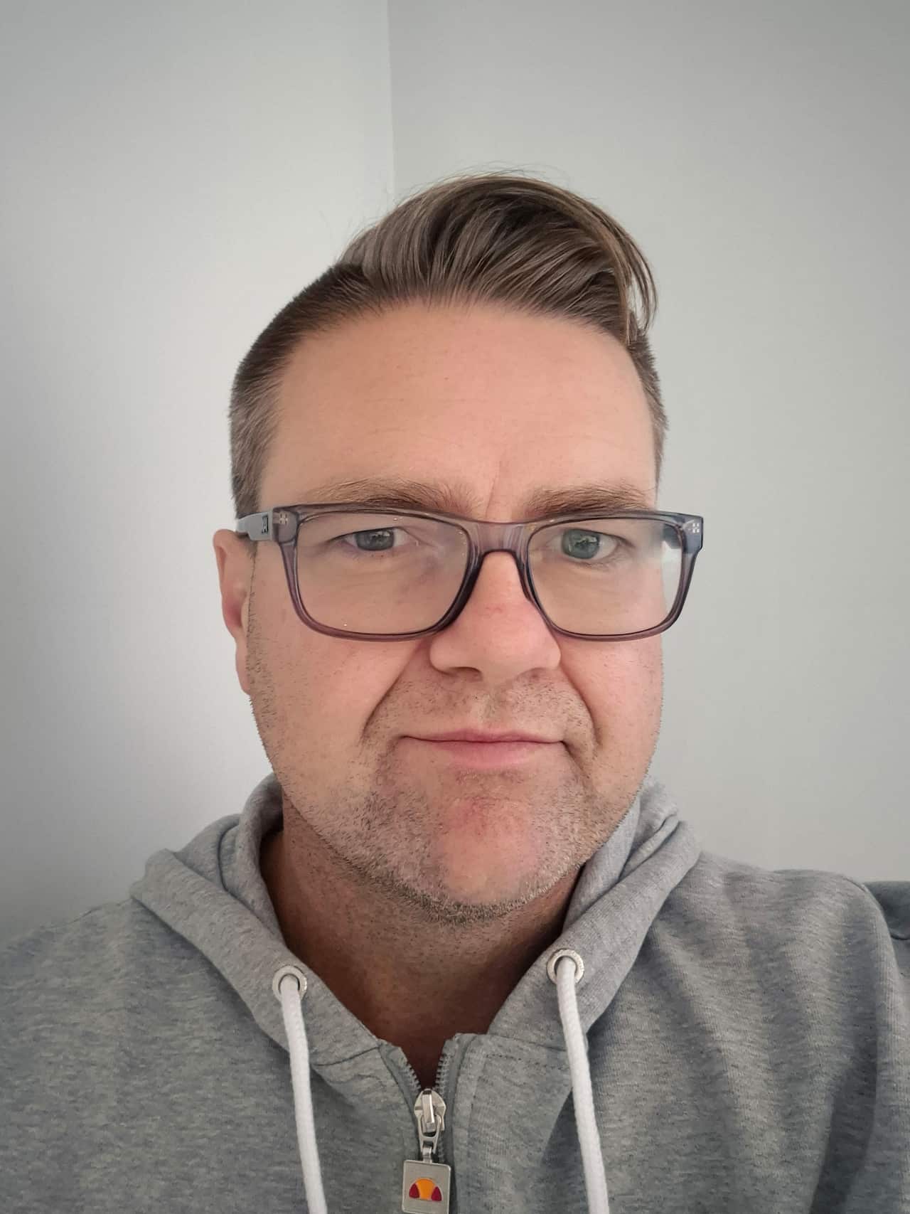 A selfie of a man in glasses with a serious expression on his face.