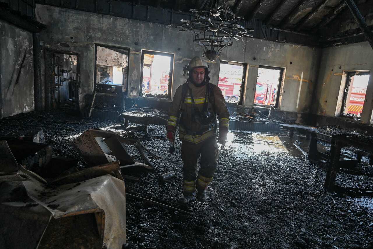 A firefighter walking through a charred room in the ski resort.
