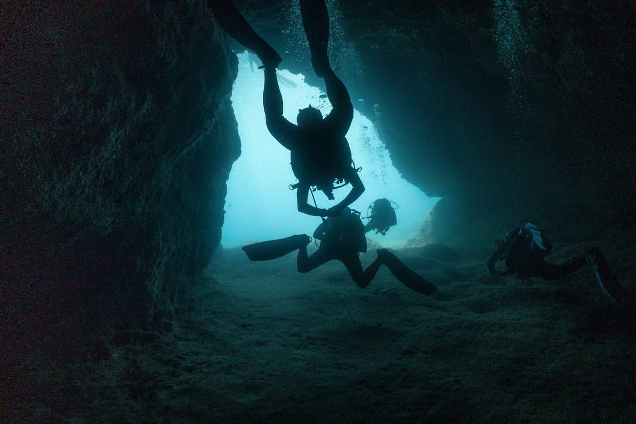 Two divers inside a cave under the sea