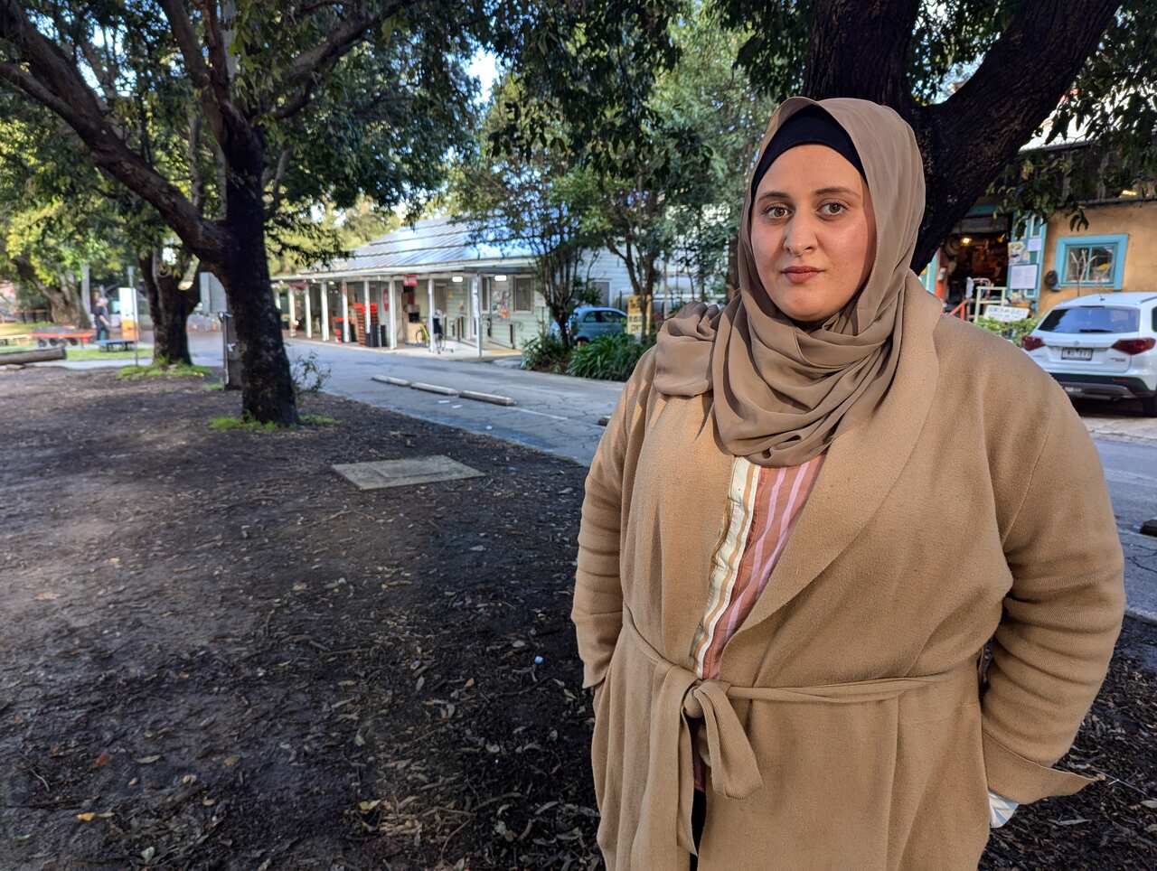A woman in a headscarf looks at the camera