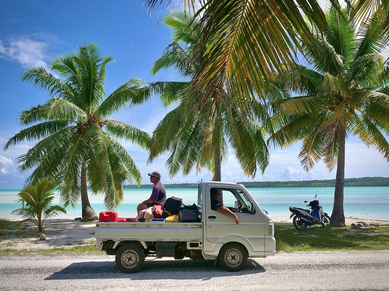 A Cook Islander rides on the back of a truck.