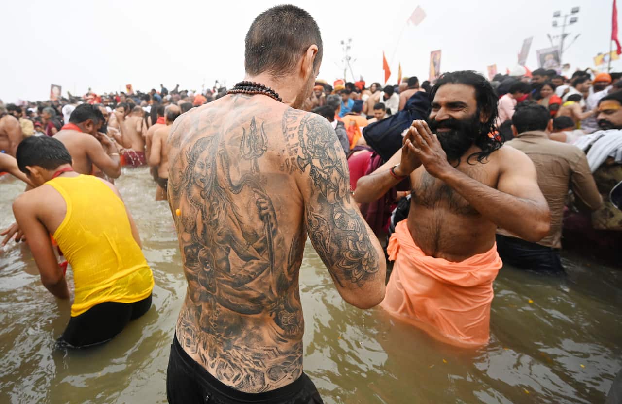 An Foreign tourist having dip during Kumbh 