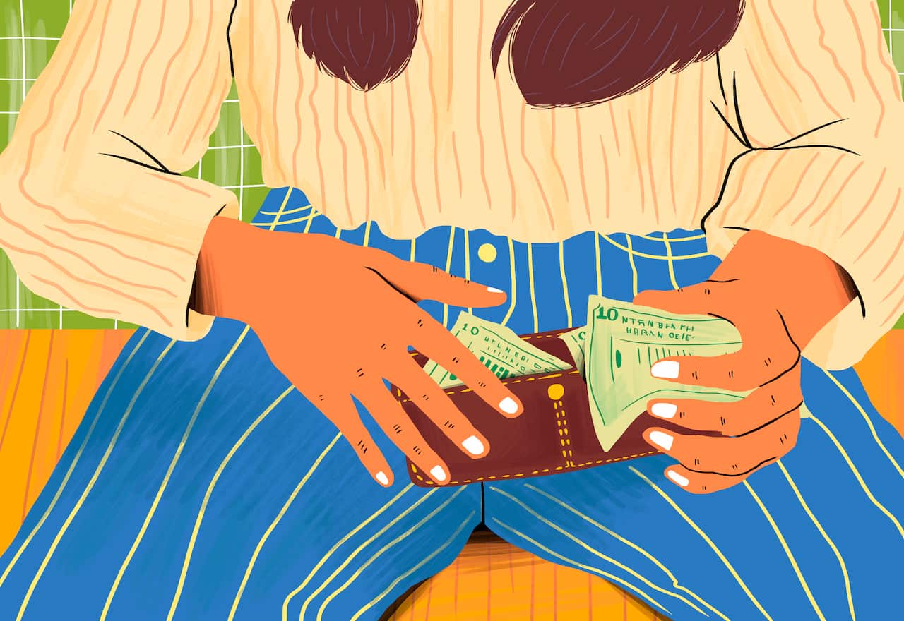Hands of woman holding a wallet with paper currency.