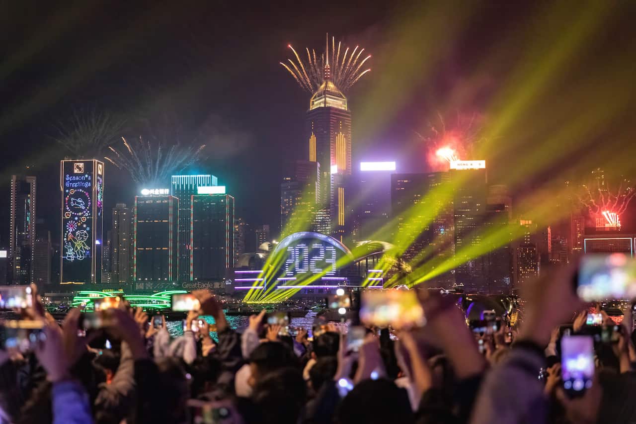 A large crowd of people watches fireworks