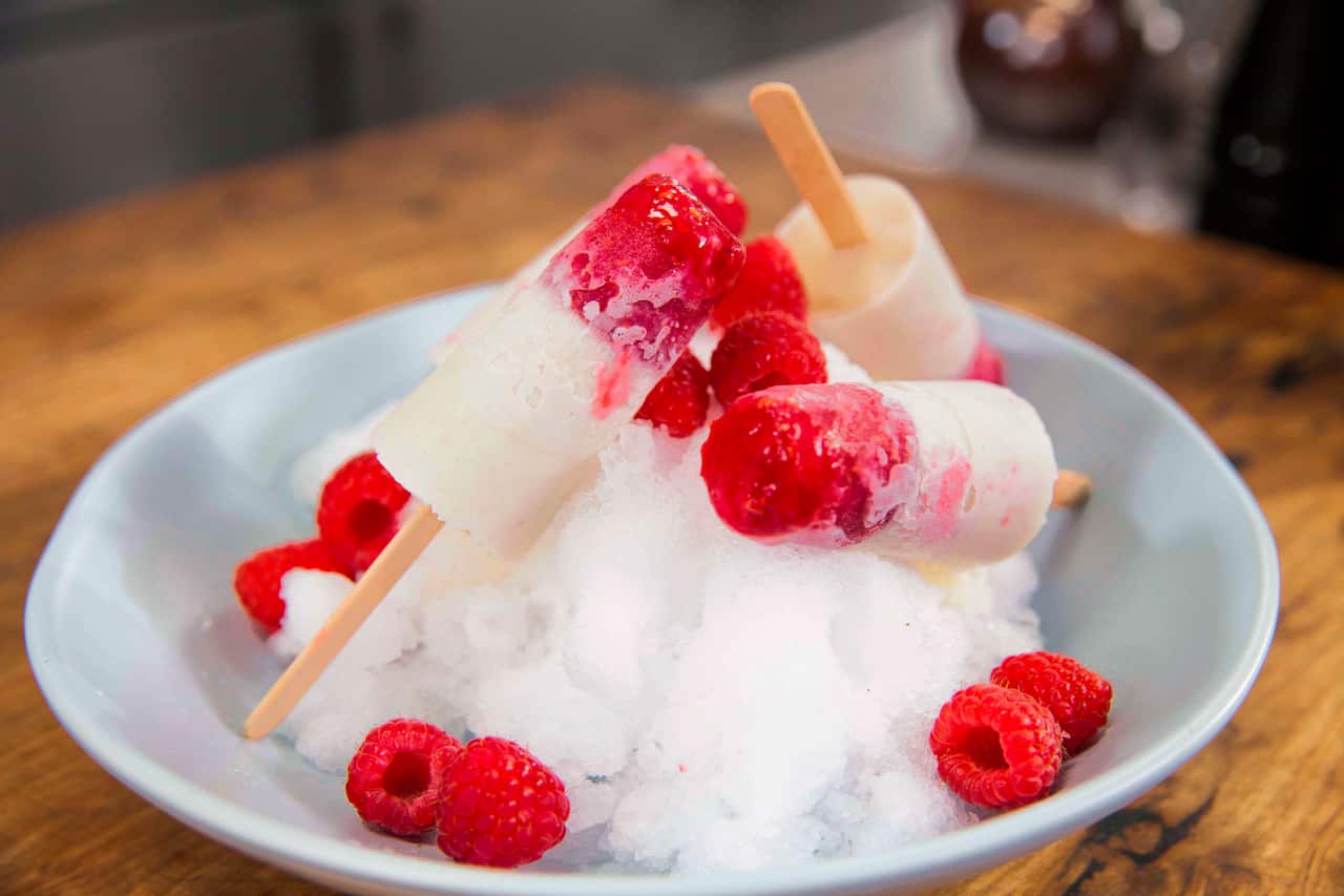 Four icypoles sit in a bowl of ice. 