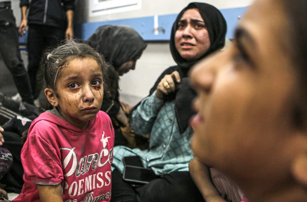 Wounded Palestinians sit in al-Shifa hospital in Gaza City, central Gaza Strip, after arriving from al-Ahli hospital following an explosion there, Tuesday, Oct. 17, 2023.