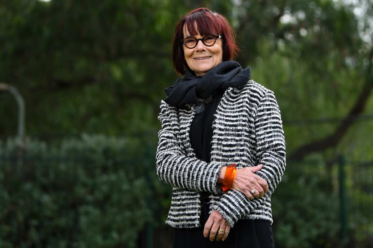 A woman in glasses wearing a black and white coat.