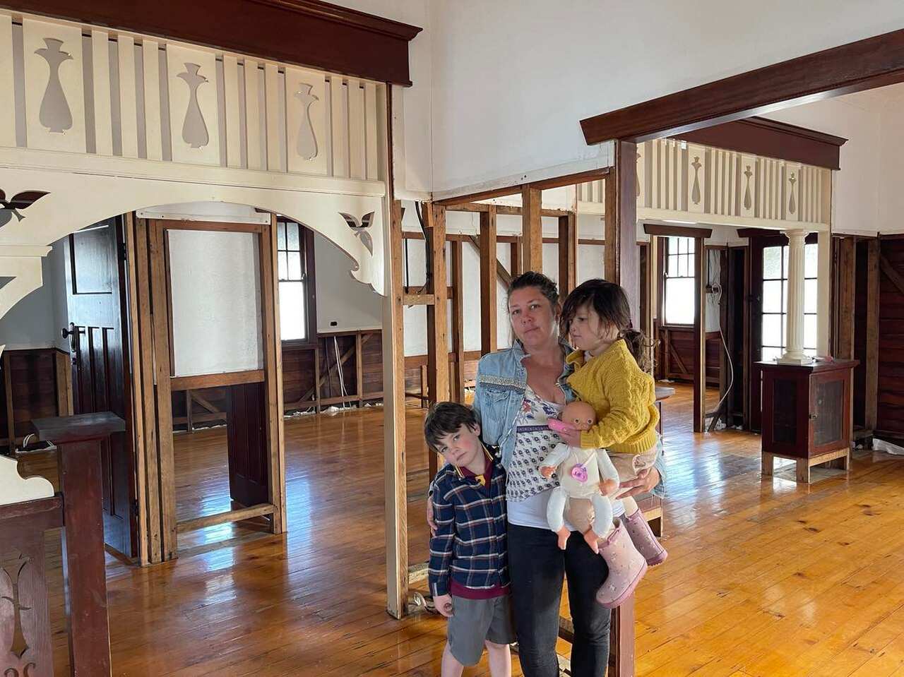 Woman and two children standing in an empty house
