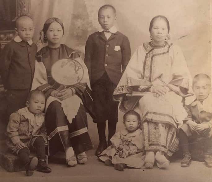 An old black and white photo of a Chinese woman with her children.