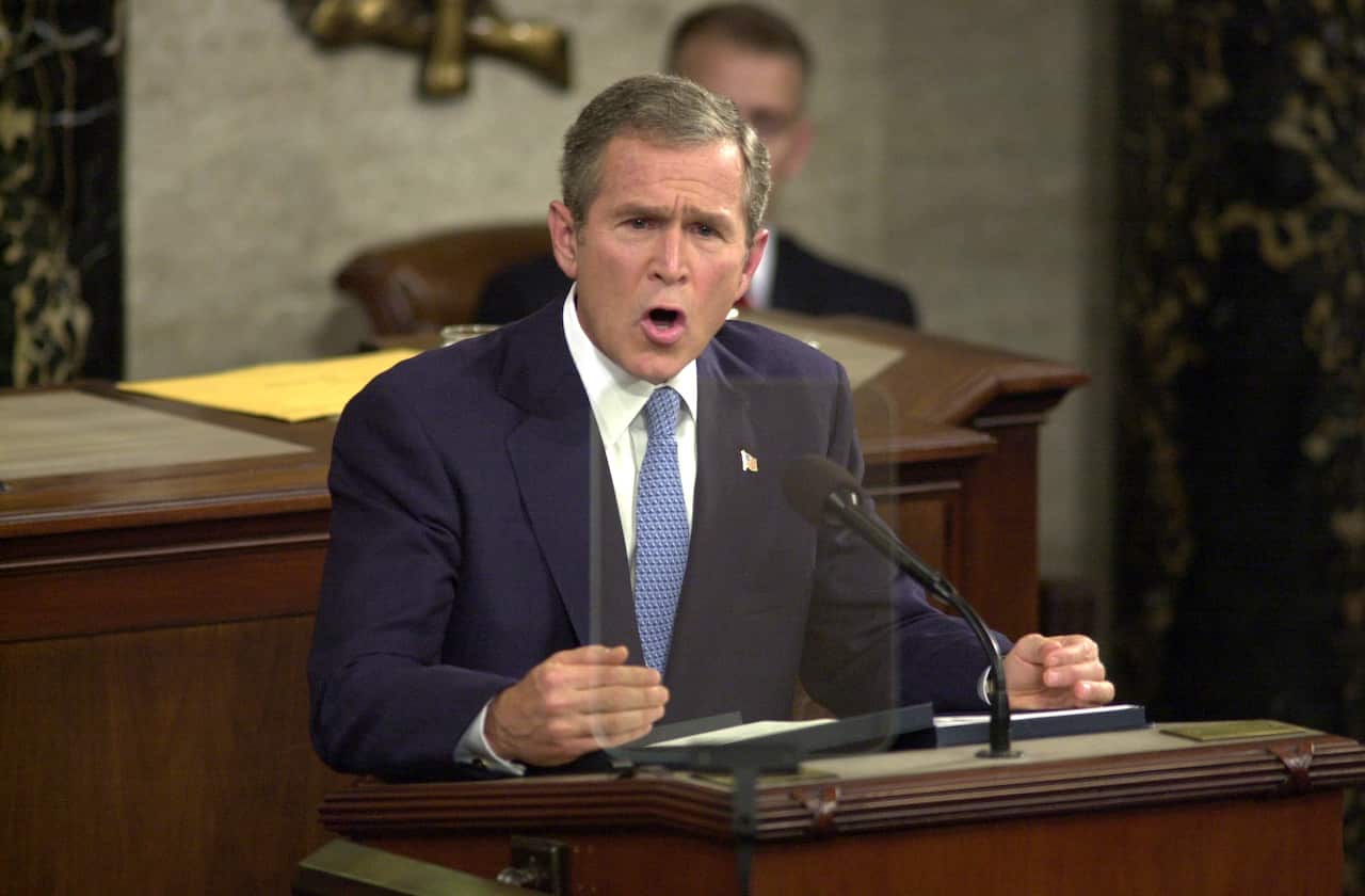 George W Bush speaks emphatically from a wooden lectern during an address to a joint session of Congress.