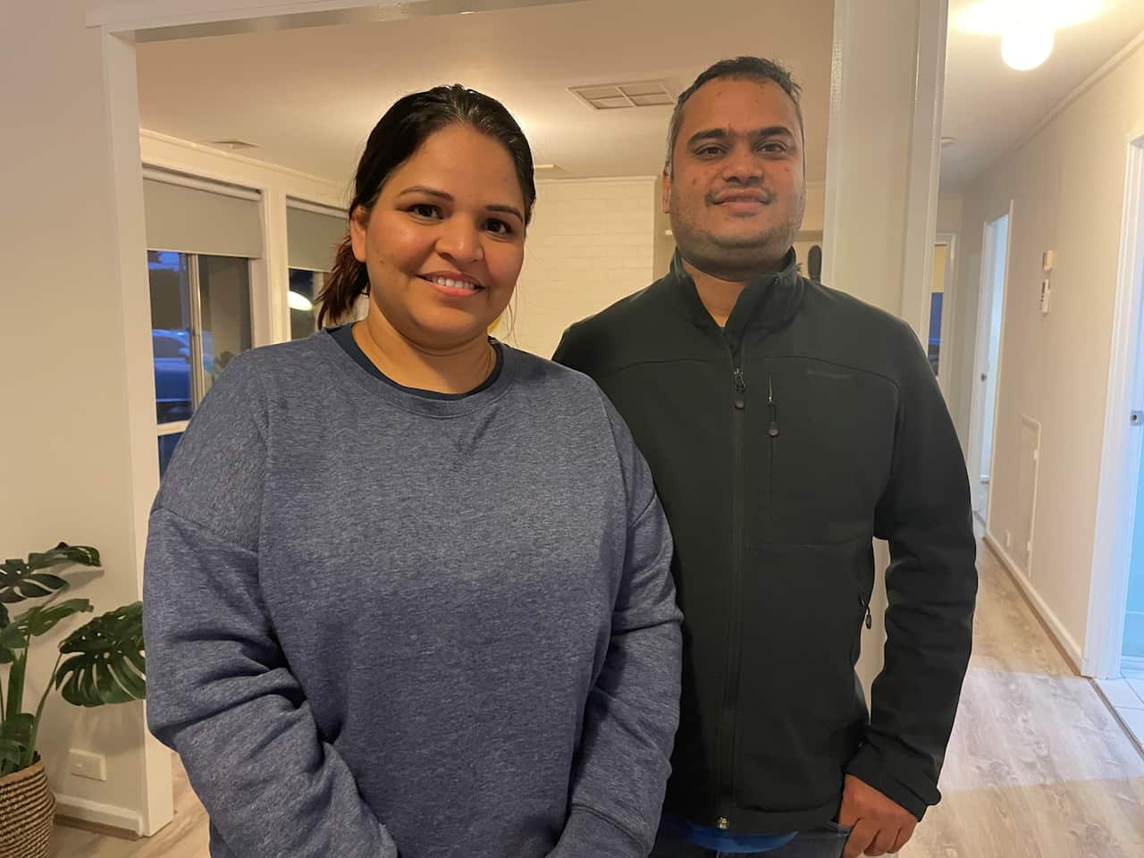 A man and a woman standing inside a house