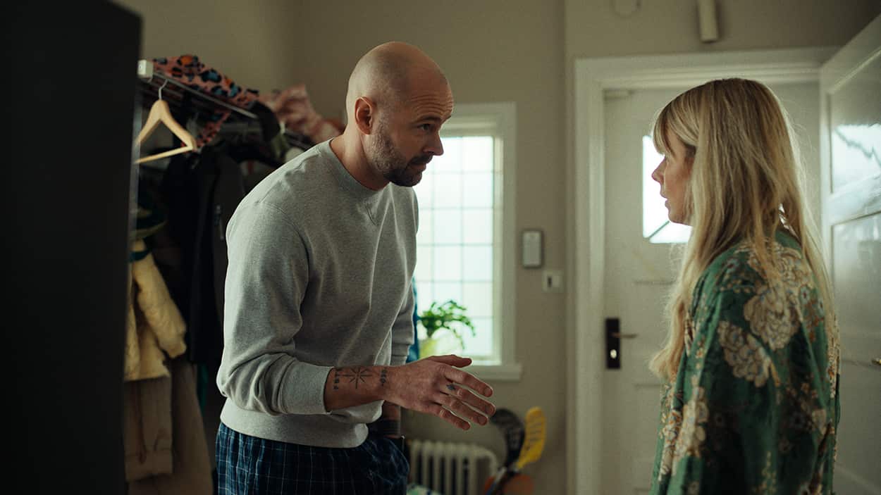 A husband and wife in mid-discussion in the hallway of their home.jpg
