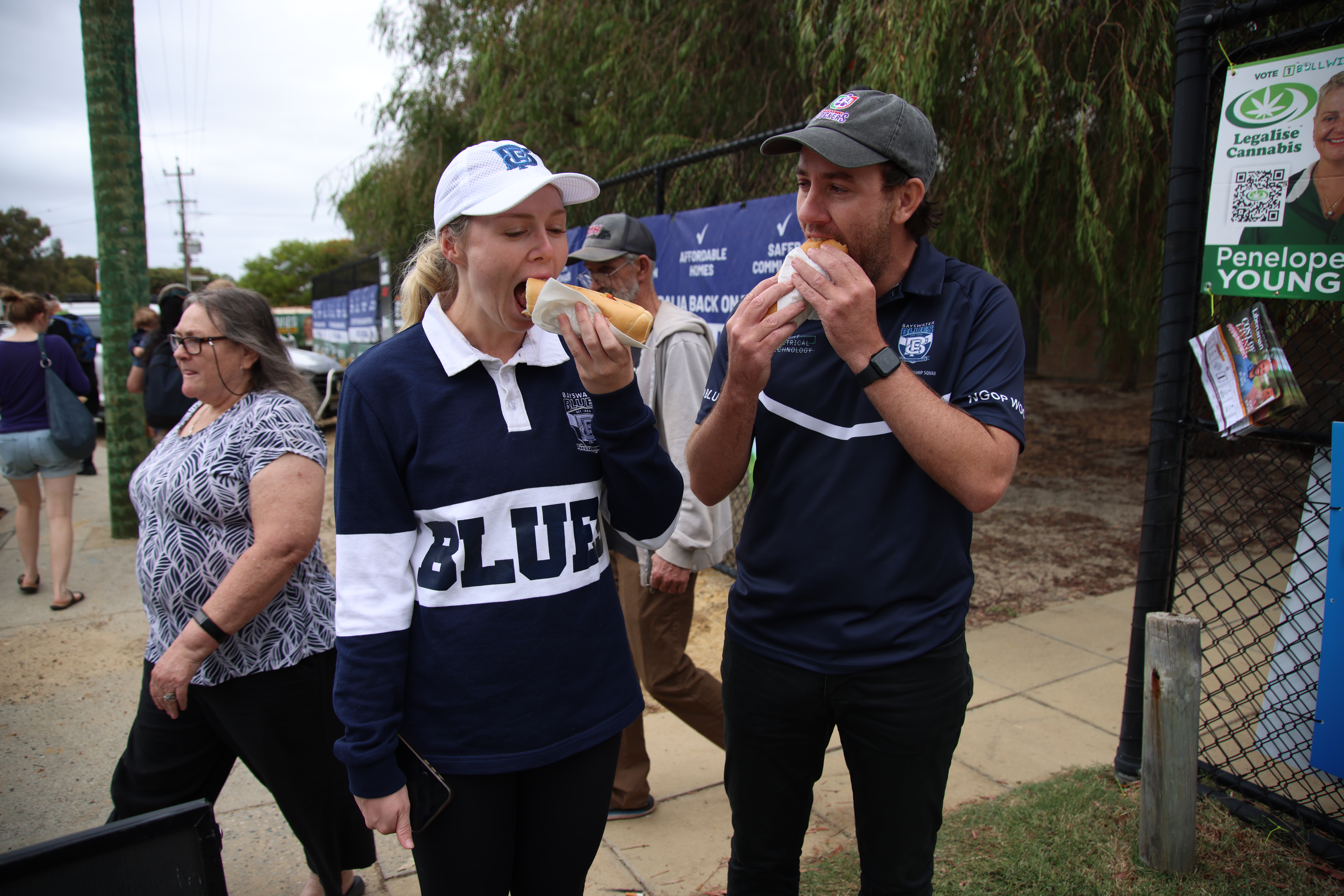 Voters eating hot dogs outside a polling centre