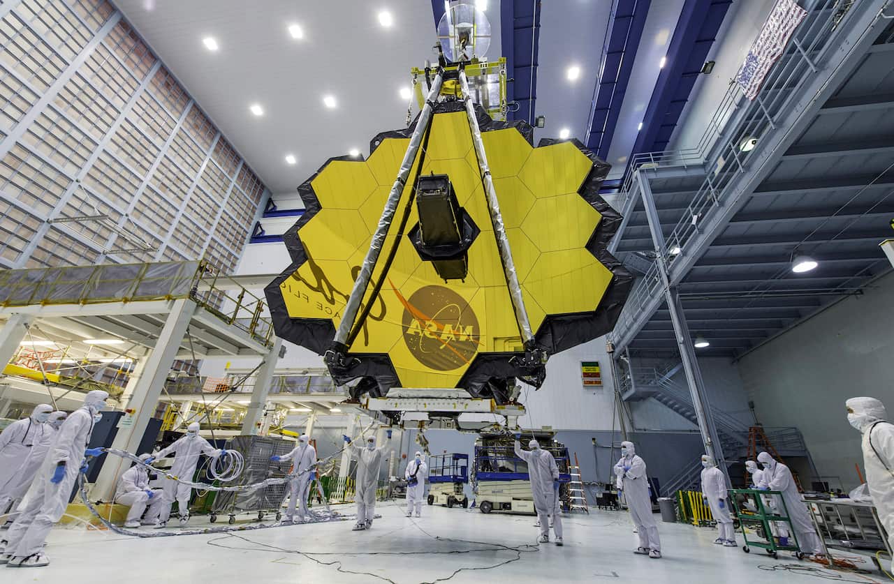Technicians lift the mirror of the James Webb Space Telescope using a crane at the Goddard Space Flight Center.