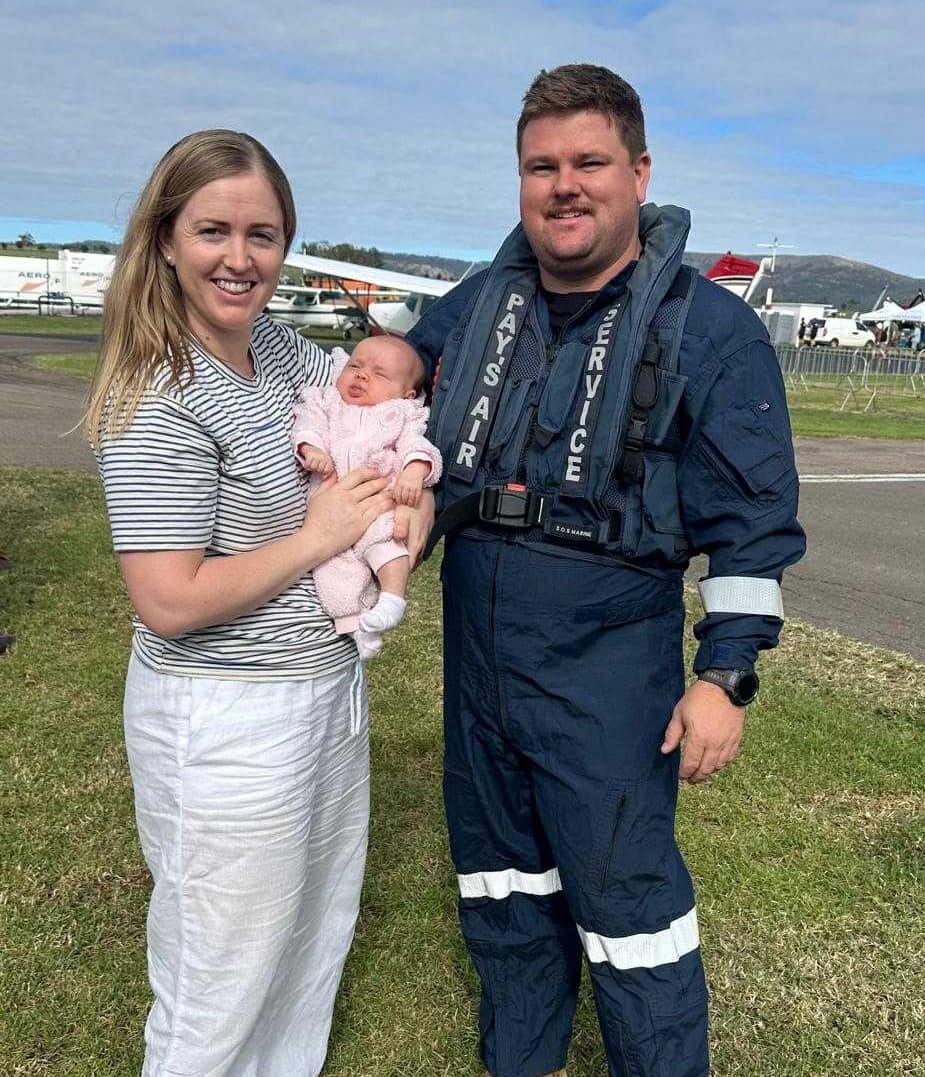 A man, woman, and their baby pose for a photo.