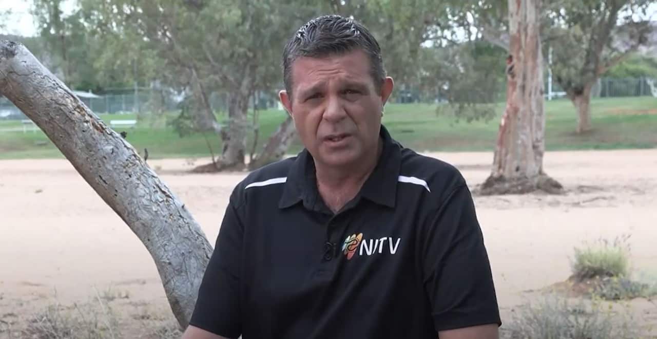 Guy McLean is seated outside wearing an NITV branded T-shirt