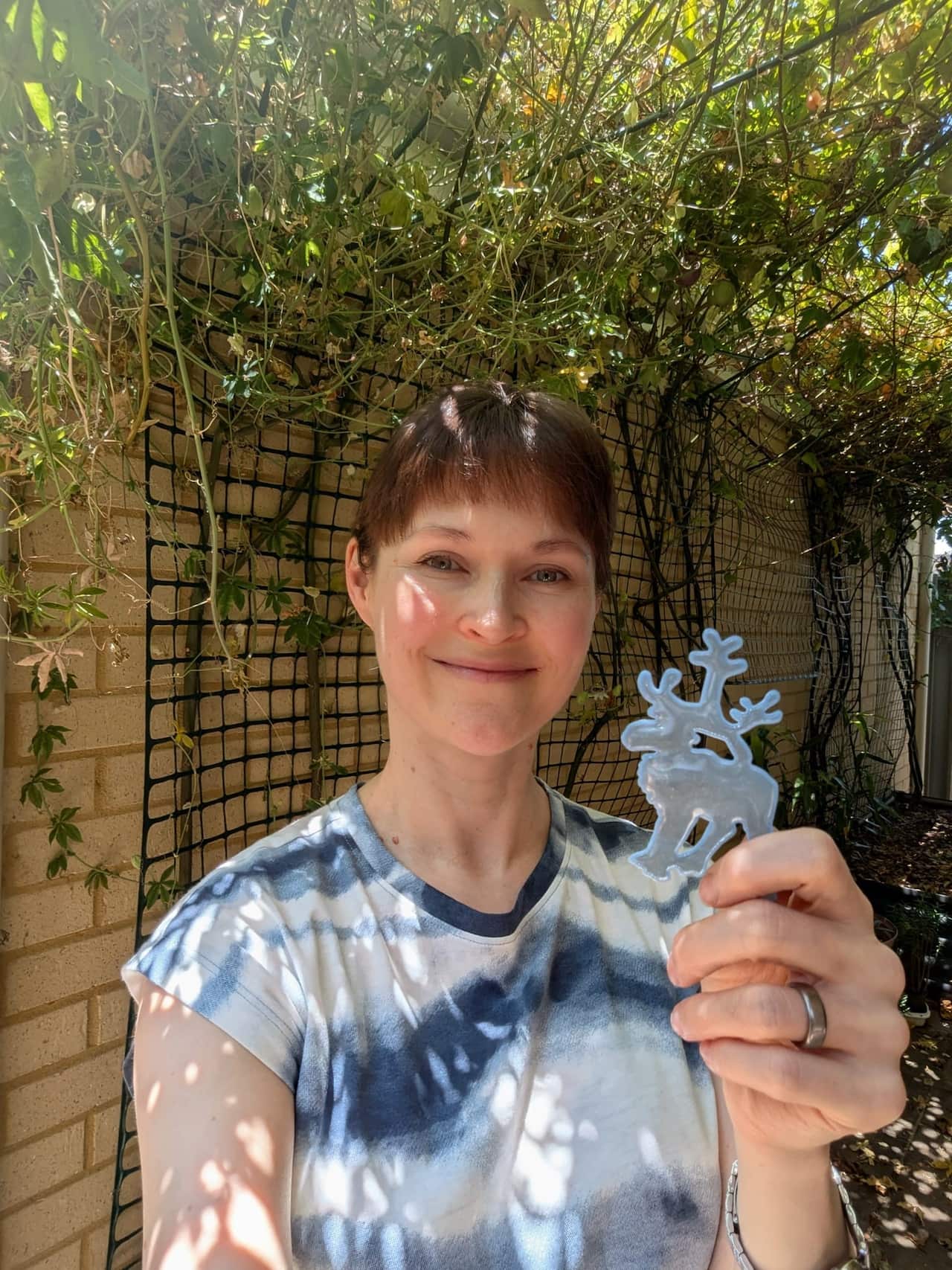 A woman holding a reindeer-shaped reflector. 