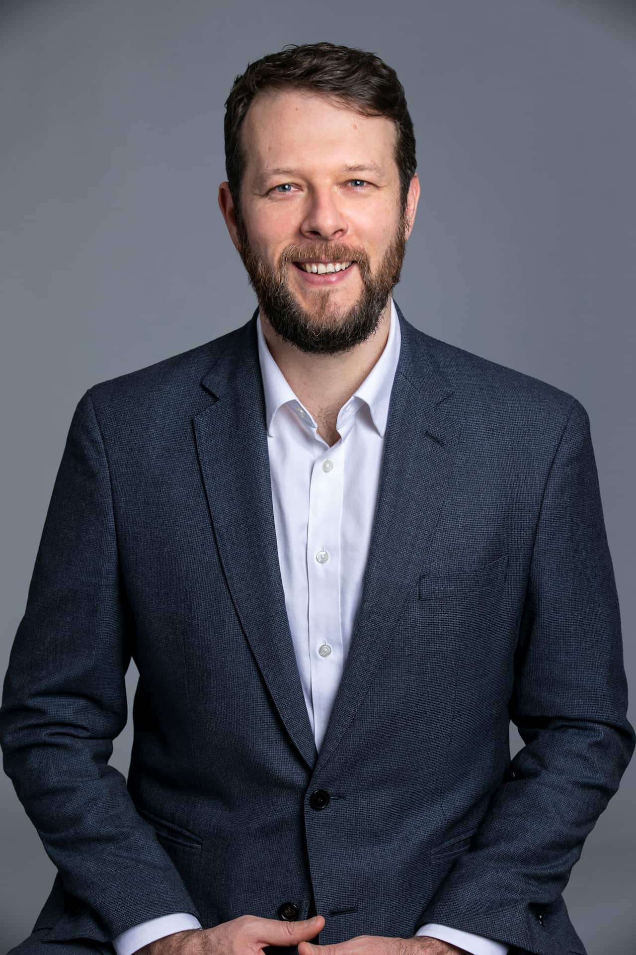 A headshot of a man in a suit