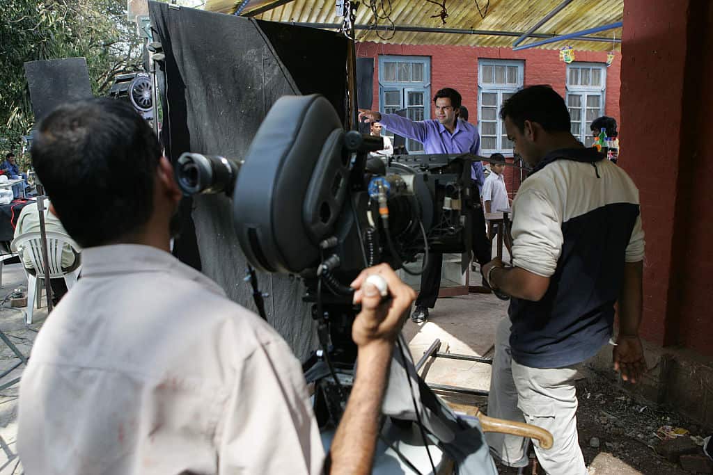A camera man films on an Indian film set.