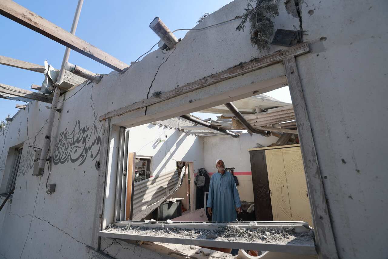 A man looking around at his damaged house.