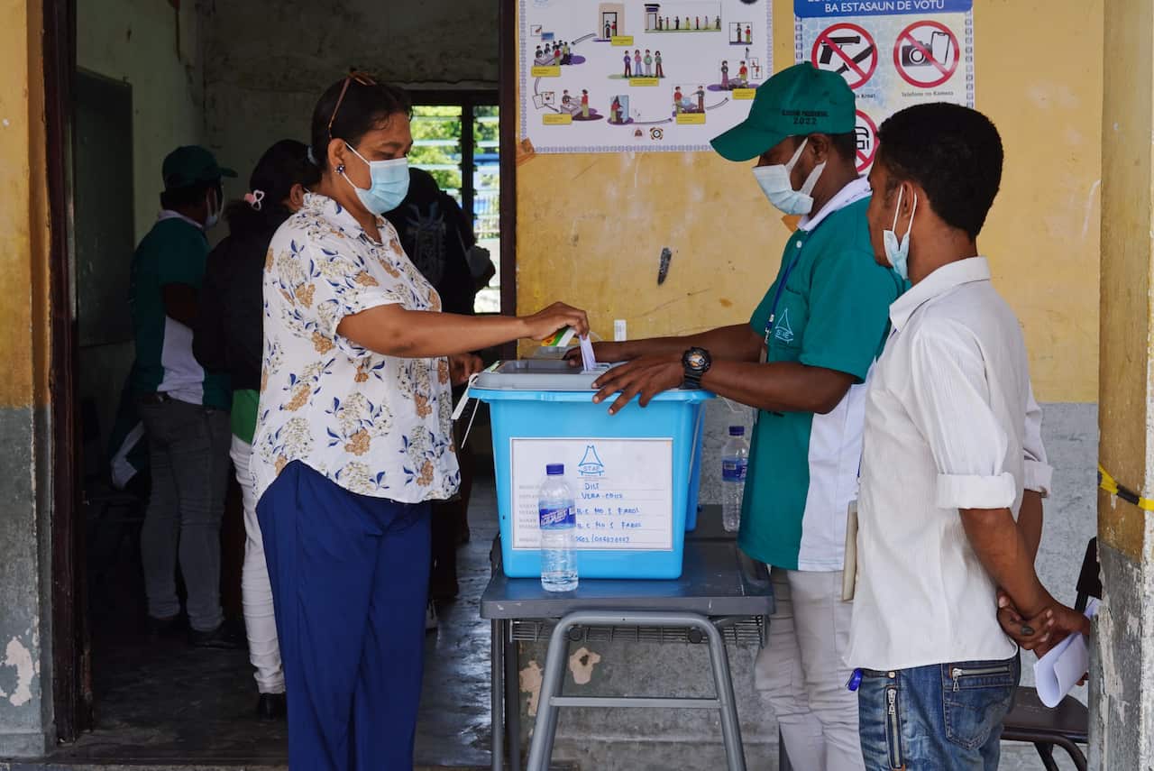 A woman places her vote in a ballot box for Timor-Leste's presidential election.