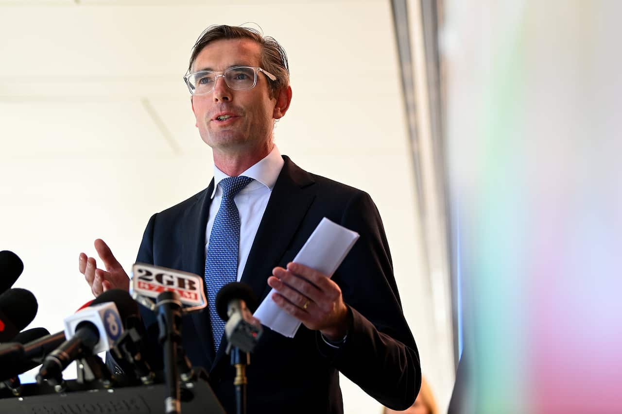 A man speaking in front of microphones.