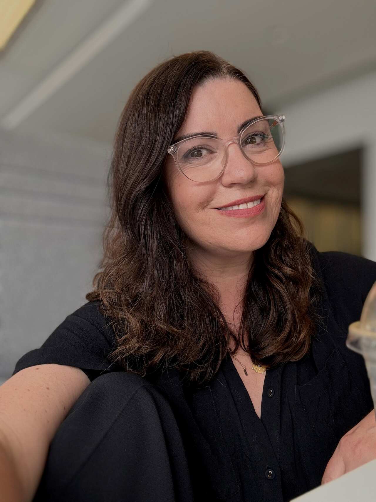A woman in a black top is smiling.