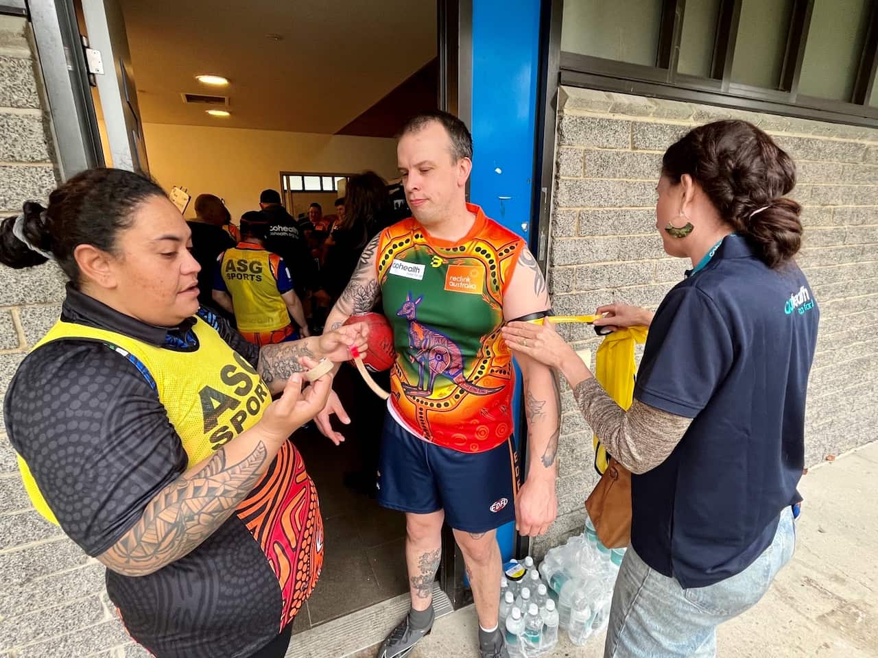 cohealth Kangas putting on an armband for player's father's death.jpg