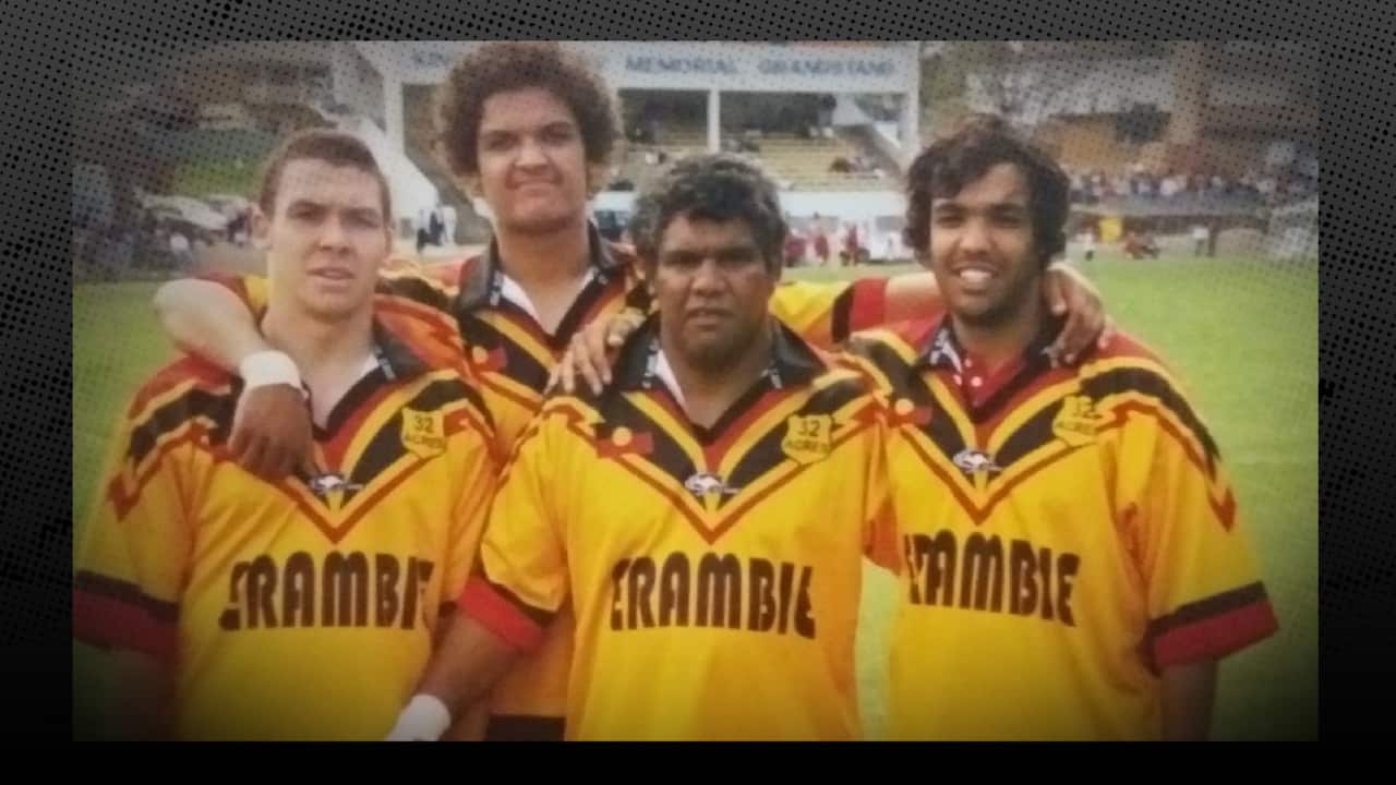 The Ingram brothers with father Steve at the centre, with arms around each others' shoulders, standing side-by-side on the football ground for an earlier Knockout, proudly wearing their yellow footy jerseys.