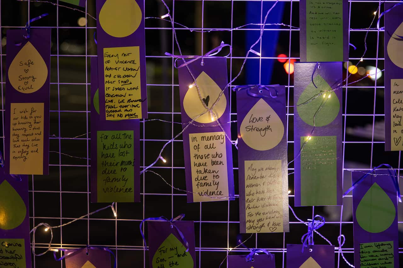 Purple cards on a wire fence at night