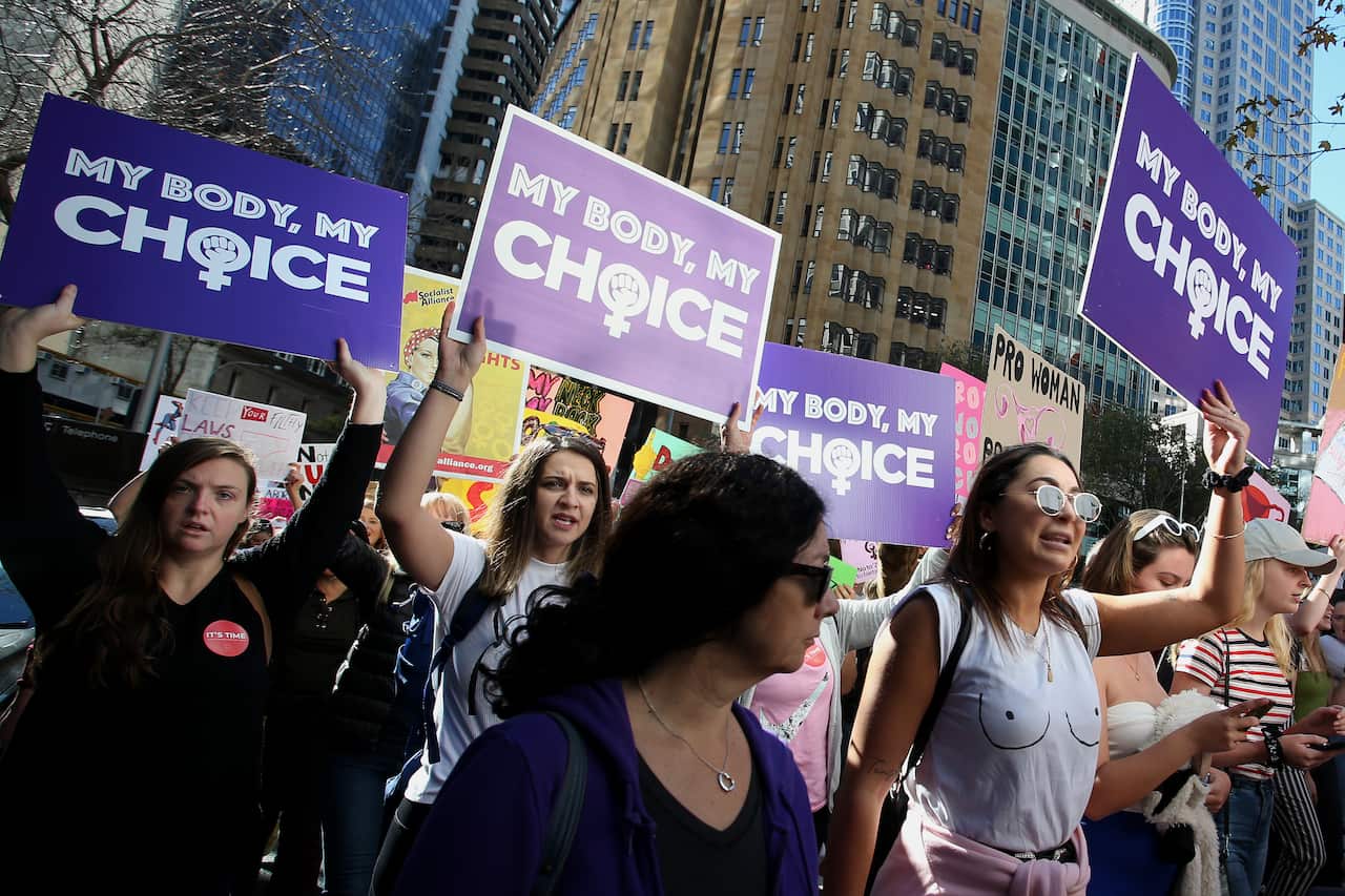 Women holding posters reading "My body, my choice" during a protest march.