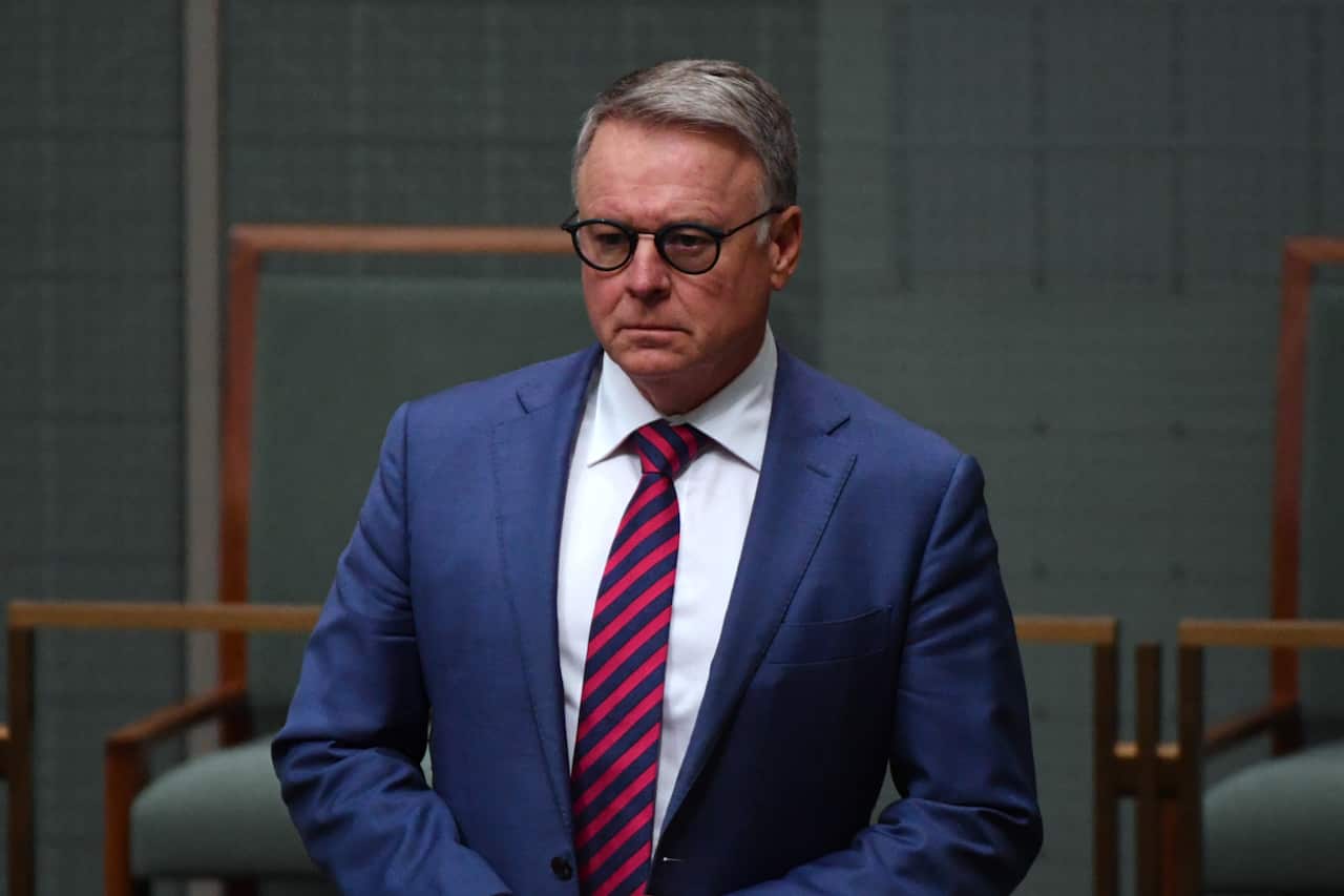 A man in a suit and tie standing in parliament
