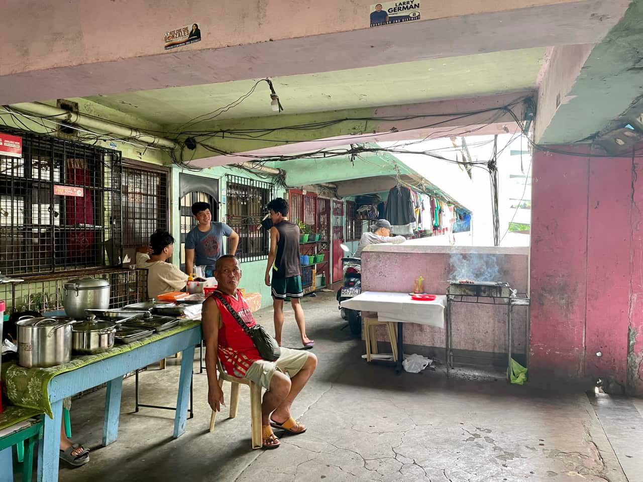 Residents outside of their apartment buildings cooking food.