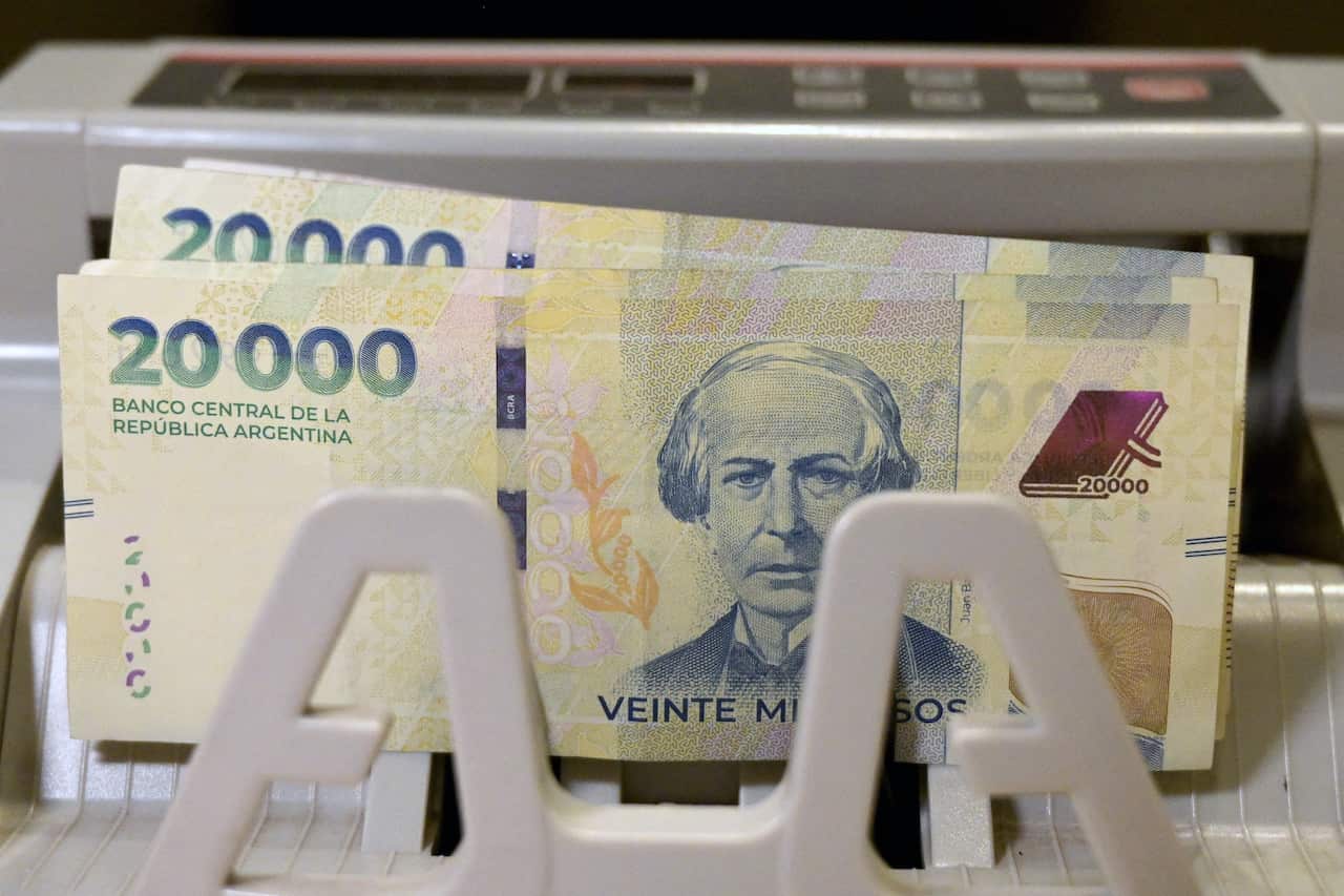 A machine counts Argentine peso banknotes.