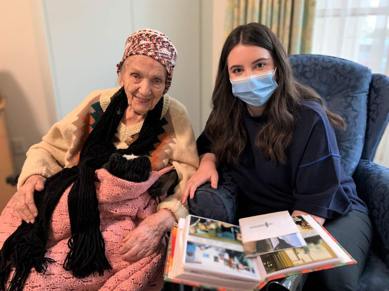 Velta Ozols looking through photos with artist Tilda Byleveld 