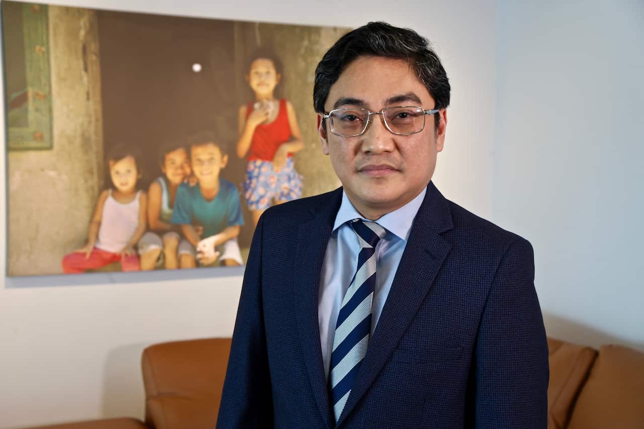 A man in a suit and tie standing in a room 