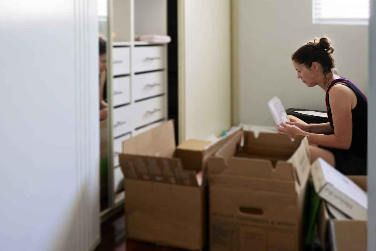 Adult woman packing documents and items into moving boxes
