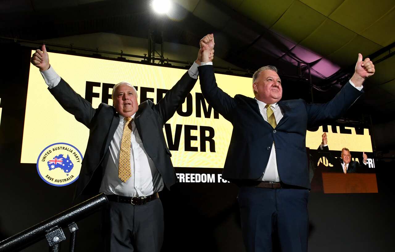 Two men raise hands. 