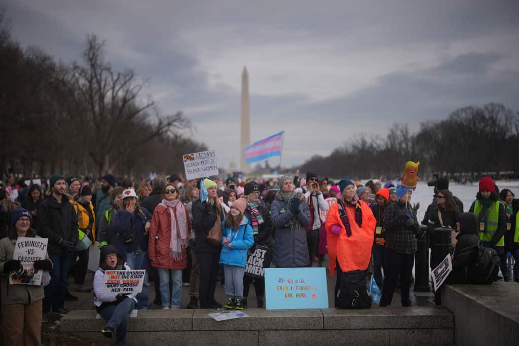 Protesters are seen at a march, holding signs.